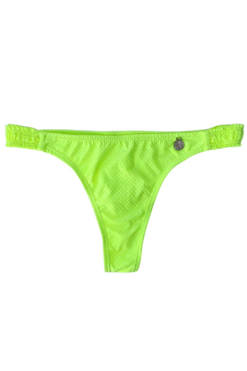 Bombacha Yellow Fluo con textura gofrada y frunce cola less de Alitas Bikinis. Bikini amarillo neón vibrante con laterales elásticos fruncidos que no marcan. Moldería cavada de tiro medio con dije plateado sobre fondo blanco.
